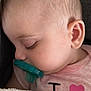 baby, sleeping, pacifier, blanket, pink_shirt, heart, close_up, face, infant, child, peaceful, soft_texture, cute, resting, indoors, young_child, head, ear, eyelashes, skin