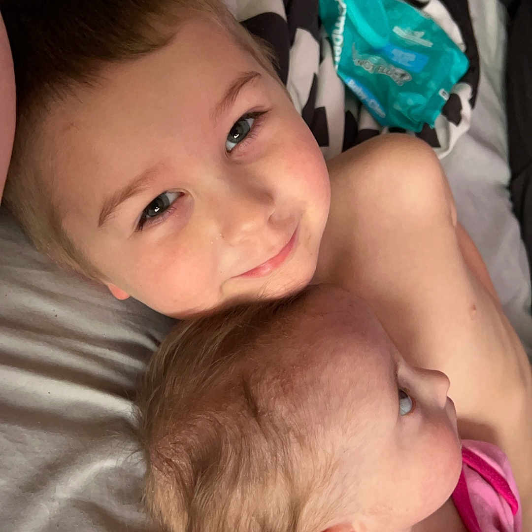 Jaxton is registered to the contest to win money with this photo: accessories, baby, bed, bedroom, blanket, bodypart, clothing, couch, cushion, earring, face, finger, frown, furniture, hand, happy, head, homedecor, indoors, jewelry