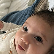 David joined the competition — help win amazing prizes! baby, infant, face, eyes, blanket, clothing, cute, portrait, skin, head, lying_down, closeup, young_child, indoors, soft_texture, expression, newborn, cozy, sleepwear, comfort