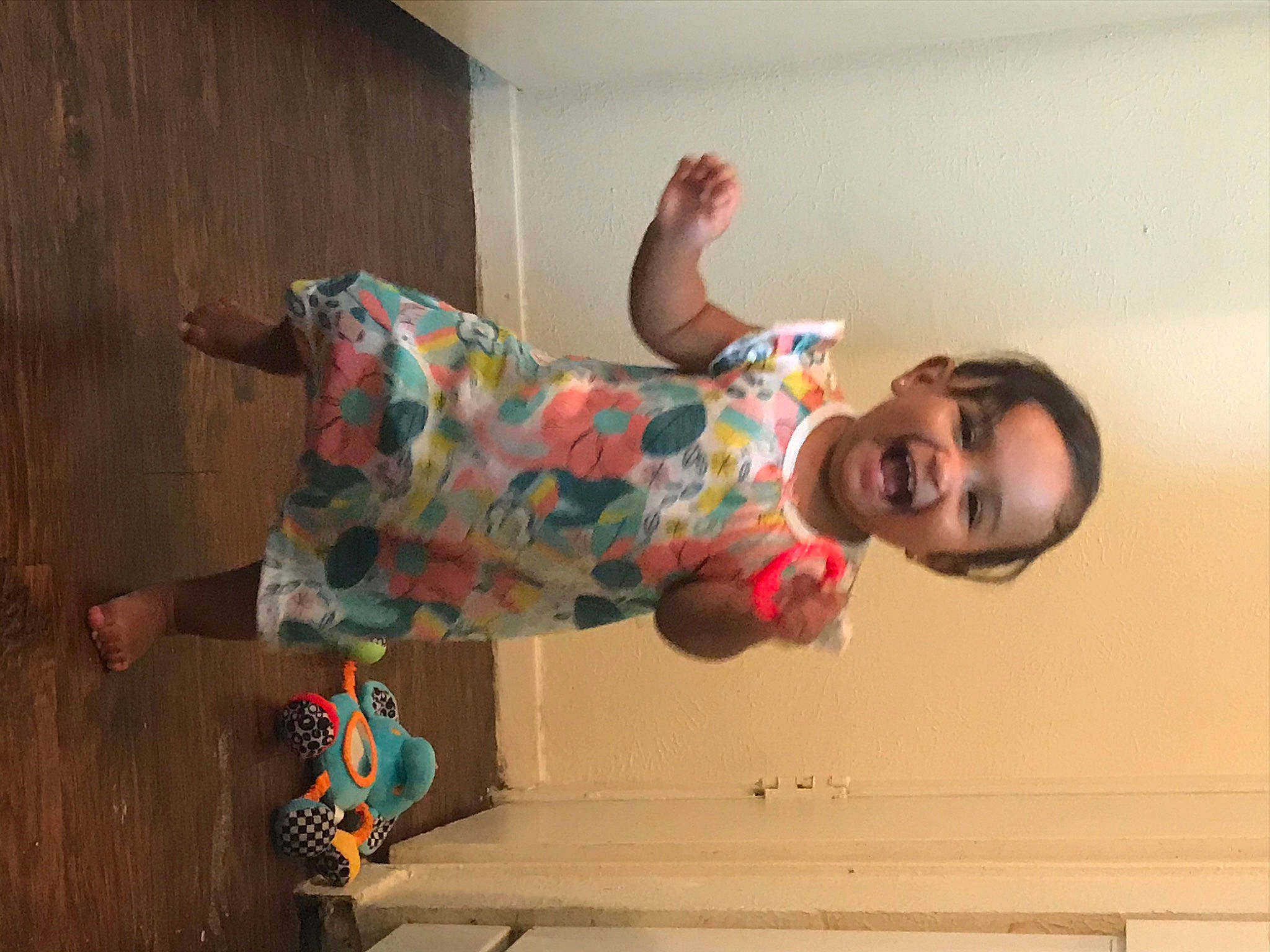 Mila Rose is registered to the contest to win money with this photo: child, elbow, floor, flooring, fun, happy, human_leg, knee, leg, pattern, person, plaster, room, sandal, sitting, smile, sock, thigh, visual_arts, wall