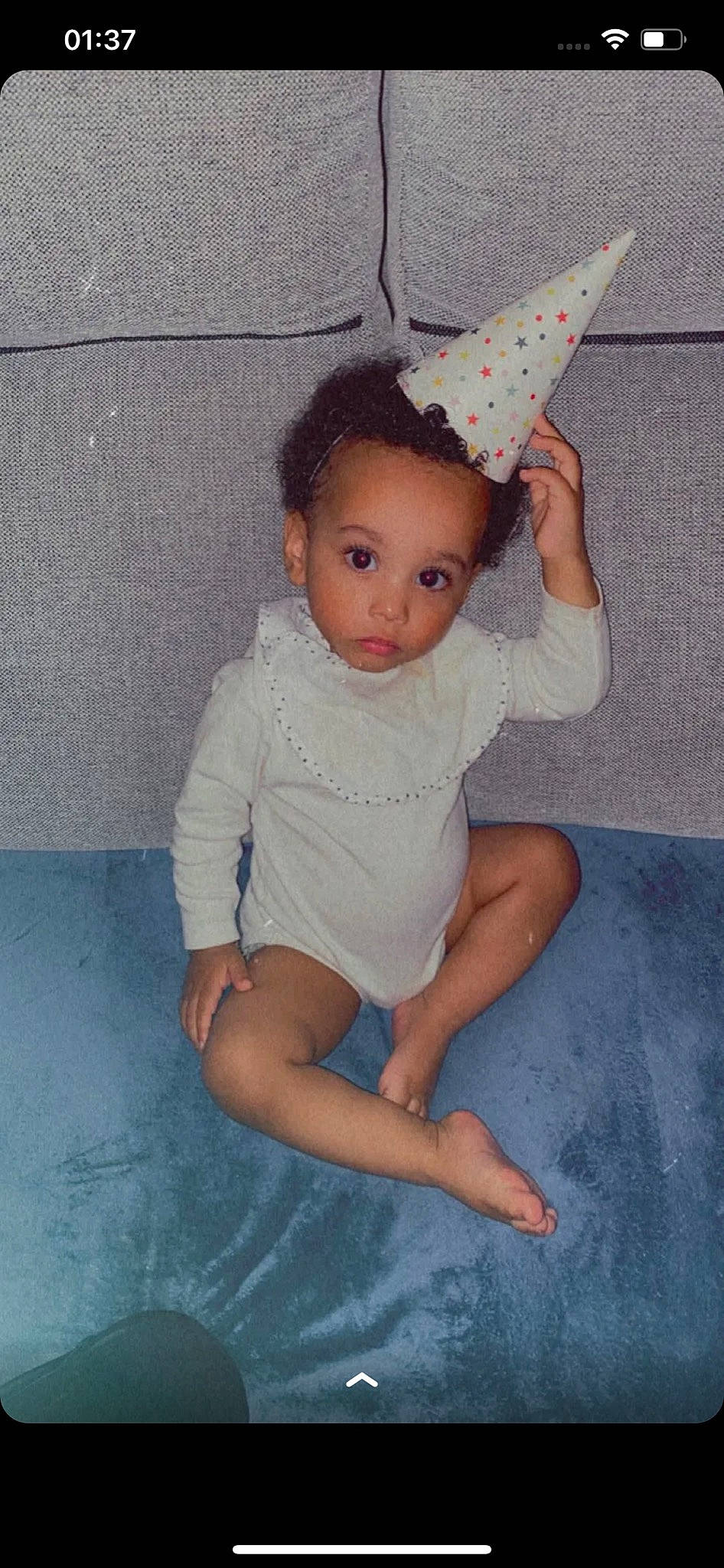 Rayan a rejoint le concours — aidez-le/la à gagner de superbes lots ! baby_toddler_clothing, child, cone, costume_hat, eye, facial_expression, floor, hair, head, knee, leg, neck, party_hat, person, photograph, pink, skin, sleeve, thigh, toddler