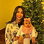 woman, baby, child, christmas_tree, holiday, smile, indoor, pajamas, headband, lights, celebration, family, holding, festive, cheerful, portrait, warm_lighting, jewelry, watch, stairs