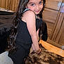 child, girl, black_dress, long_hair, bow, smile, indoor, carpet, wooden_cabinet, furniture, posing, cute, portrait, stockings, happy, young, fashion, home, floor, room