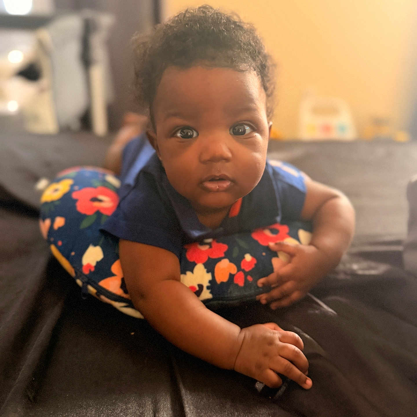 Jiovonni joined the competition — help win amazing prizes! baby, infant, child, portrait, sitting, couch, leather, pillow, floral, colorful, indoors, home, warm_lighting, curly_hair, dark_skin, wide_eyed, looking_at_camera, hands, casual_clothing, photography