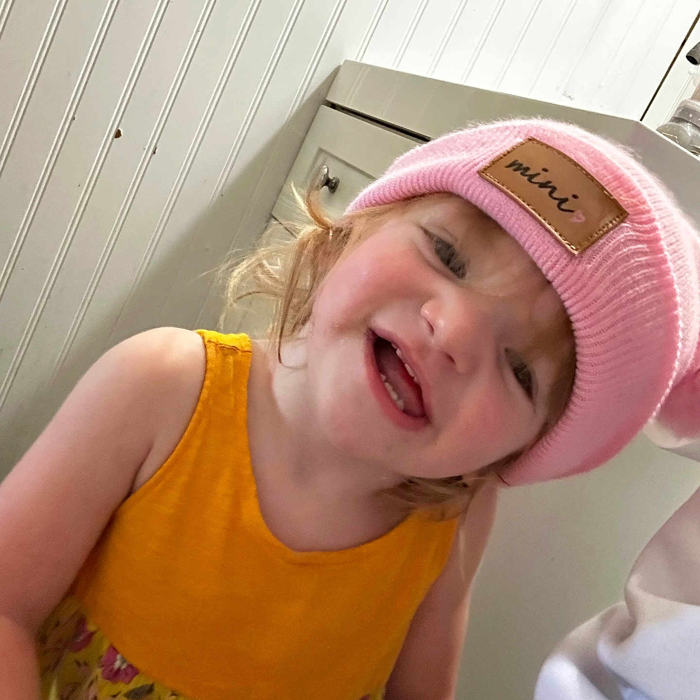Ruby joined the competition — help win amazing prizes! baby, cabinet, child, clothing, cute, expression, face, hair, happy, headwear, indoor, person, pink_hat, playful, portrait, room, skin, smiling, toddler, yellow_dress