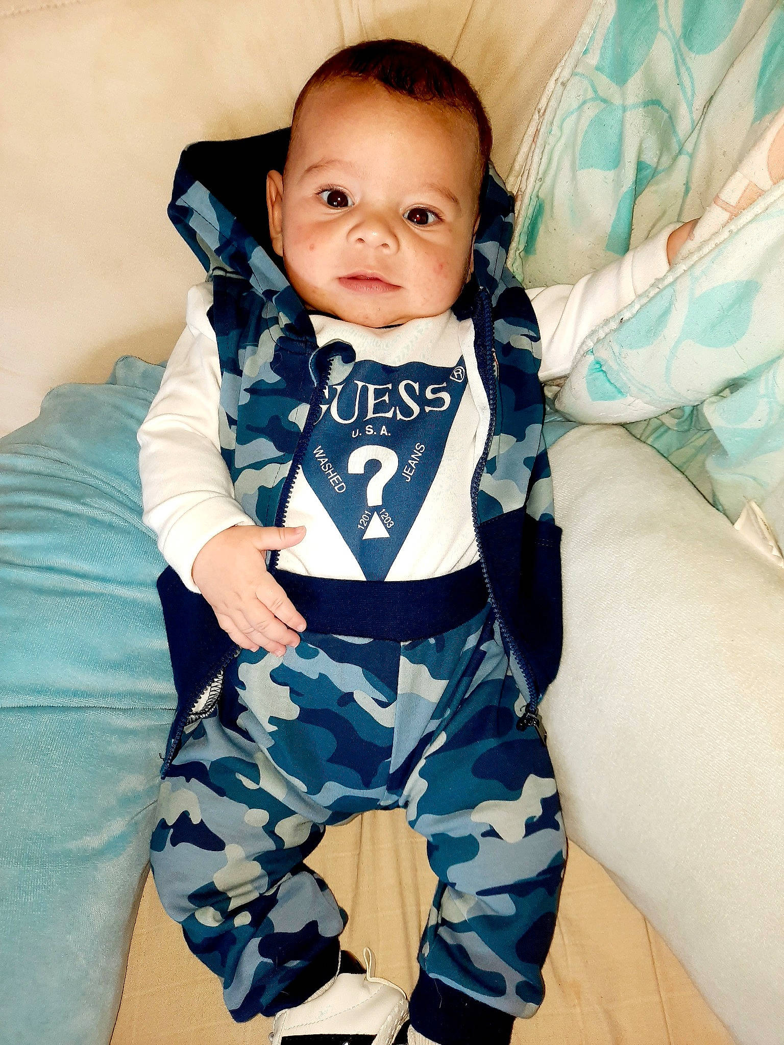 Issa participe au concours pour gagner de l'argent avec cette photo : baby, baby_products, baby_toddler_clothing, blue, camouflage, child, cool, outerwear, person, product, sleeve, smile, toddler