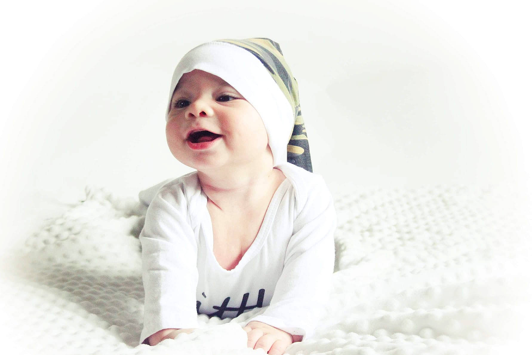 Issa participe au concours pour gagner de l'argent avec cette photo : baby, cap, child, comfort, dress, face, fashion_accessory, flash_photography, fur, gesture, happy, hat, headgear, headwear, lip, person, sitting, sleeve, smile, street_fashion