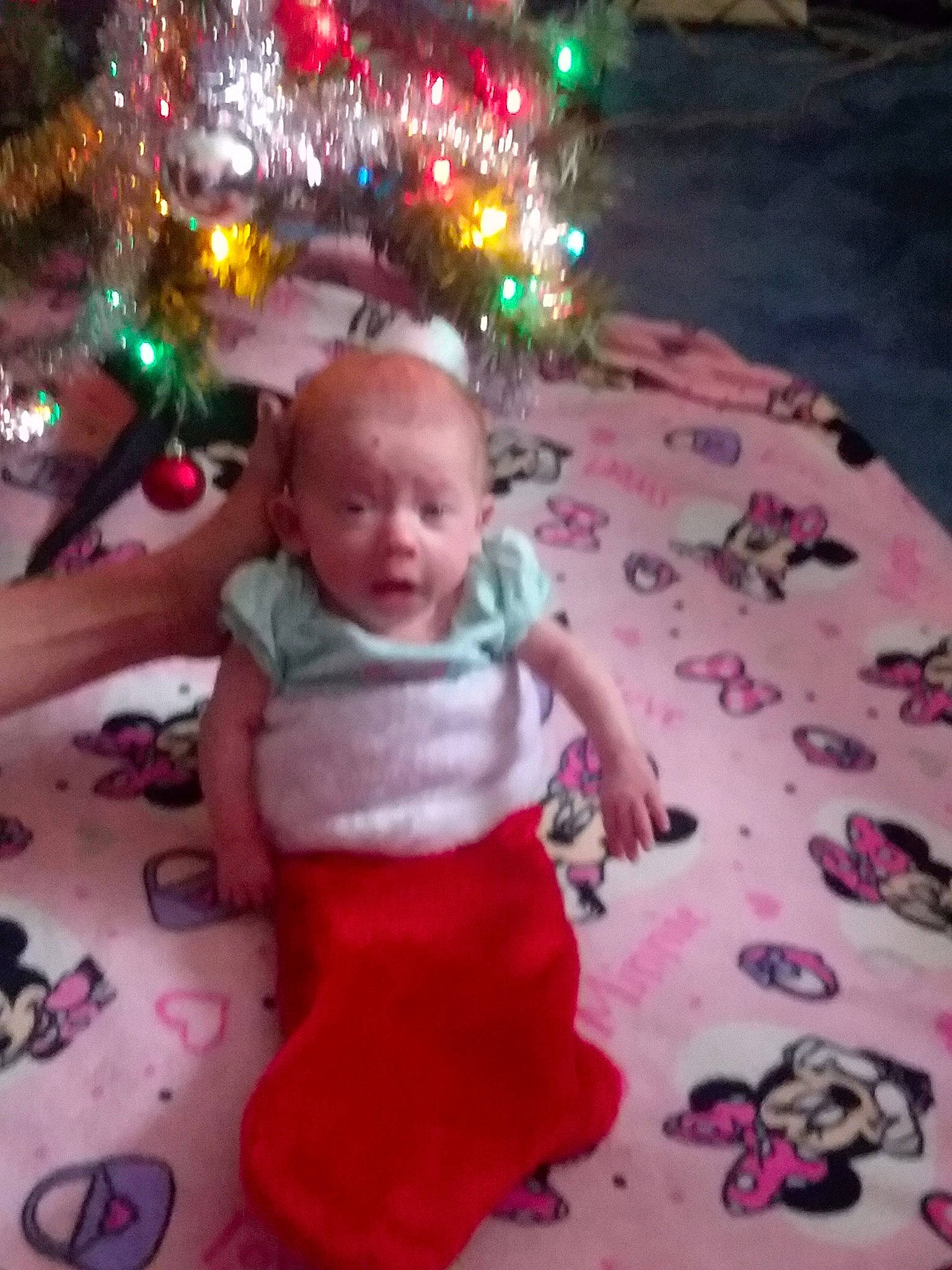 Leona is registered to the contest to win money with this photo: child, christmas, christmas_decoration, christmas_ornament, christmas_tree, day, event, facial_expression, fun, holiday, infant, mouth, person, pink, play, product, red, skin, smile, textile