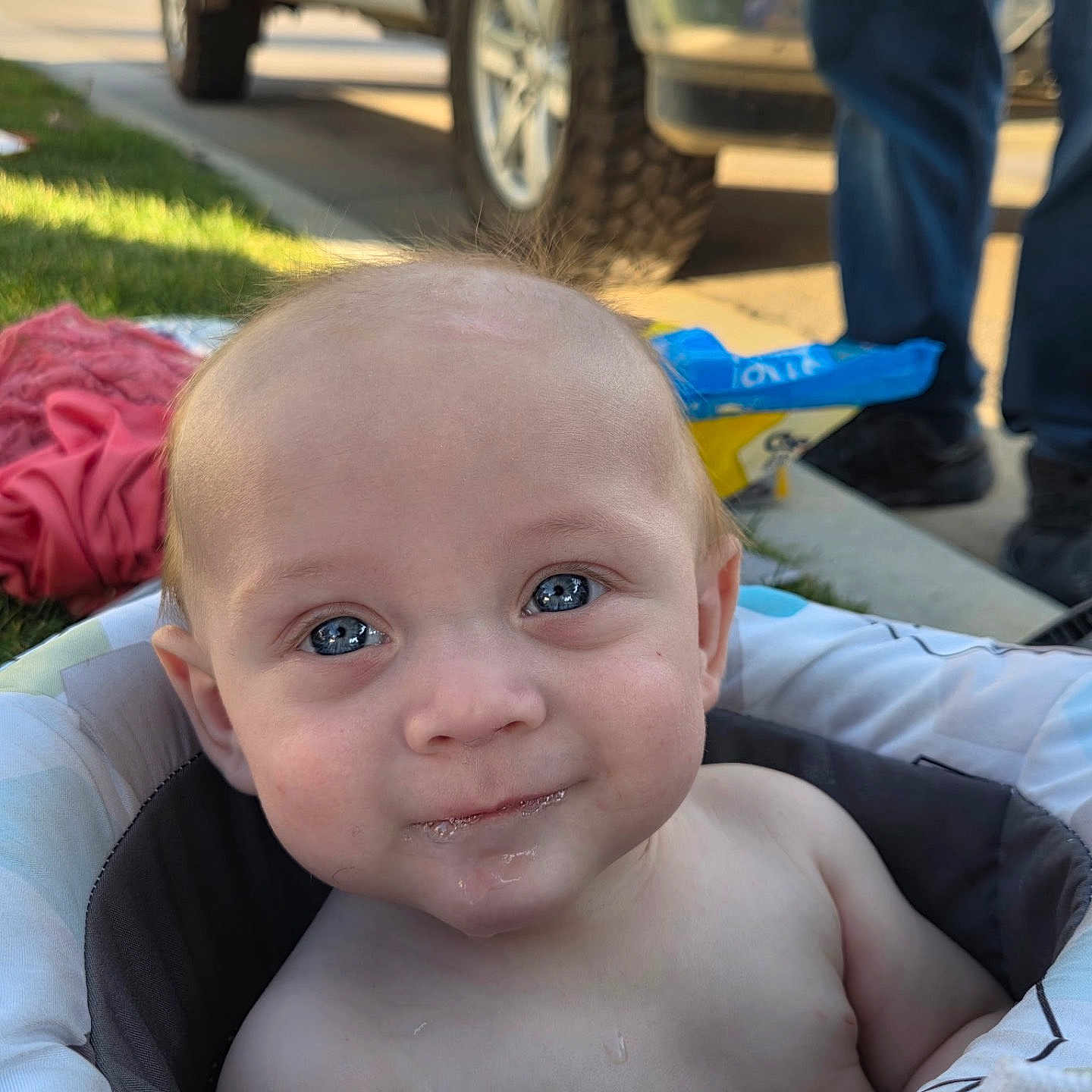 Daxx is registered to the contest to win money with this photo: baby, background, blue_eyes, child, clothing, cushion, expression, face, grass, happy, head, infant, outdoor, person, portrait, seat, skin, smile, sunlight, vehicle
