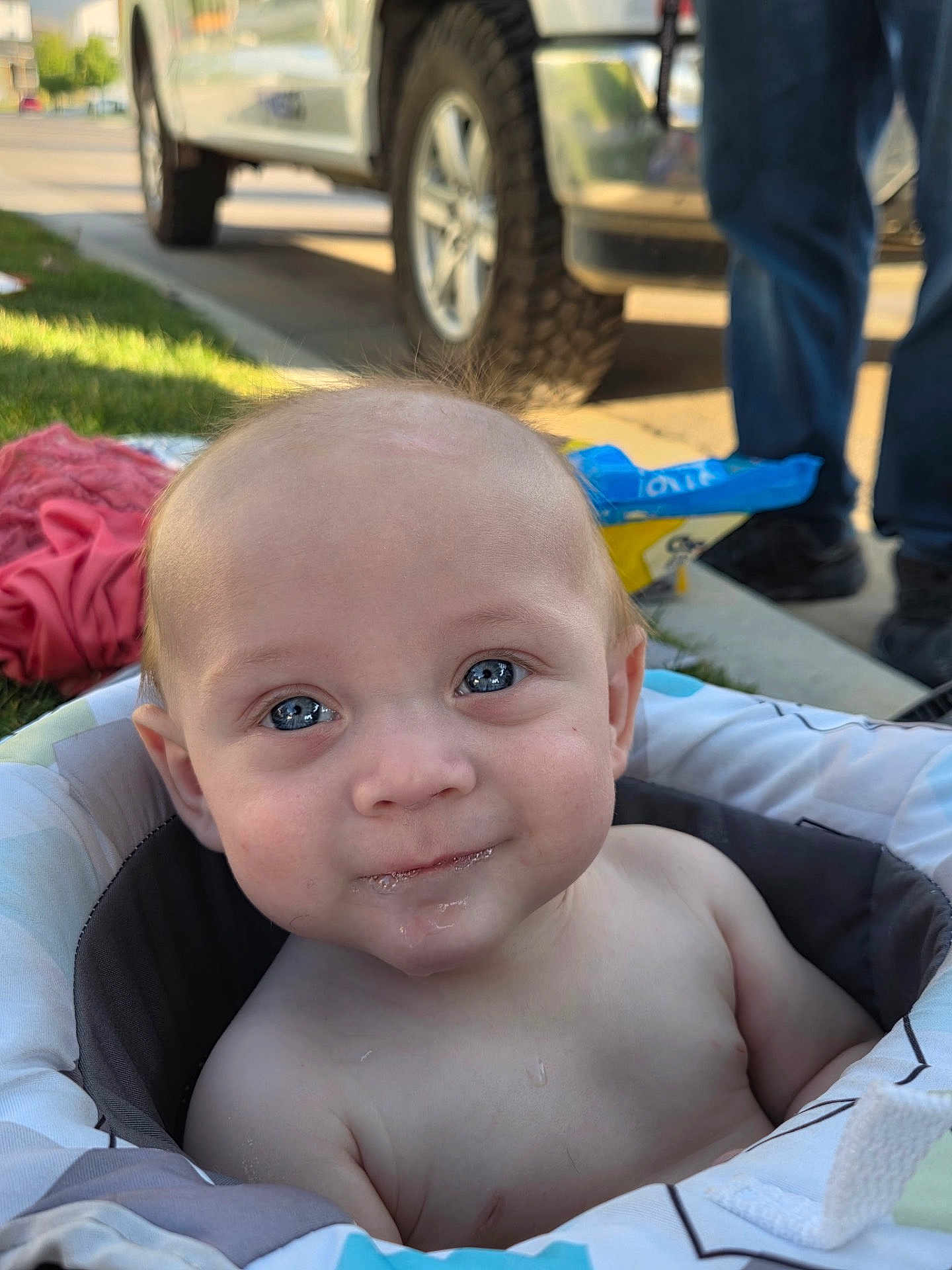 Daxx is registered to the contest to win money with this photo: baby, child, blue_eyes, smile, face, outdoor, seat, cushion, person, vehicle, grass, sunlight, clothing, happy, portrait, skin, head, infant, expression, background