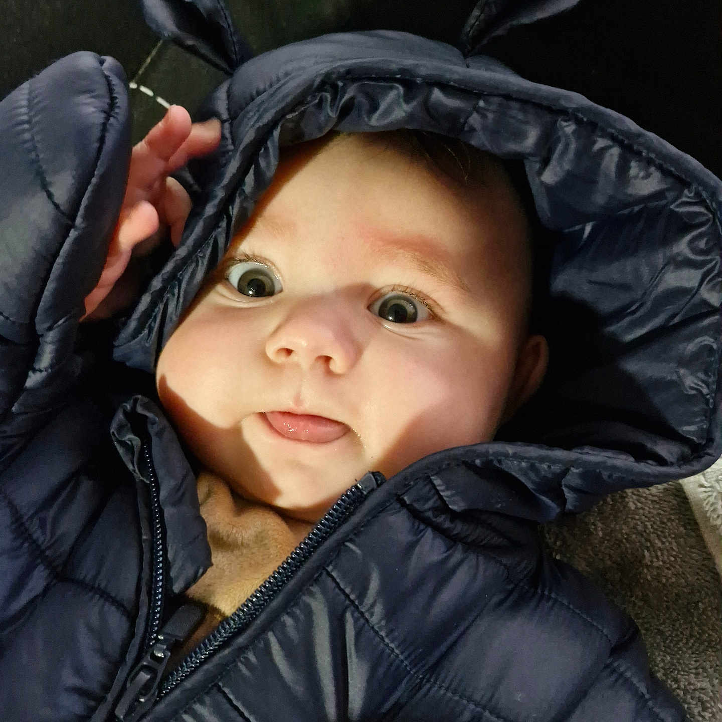 Loïs participe au concours pour gagner de l'argent avec cette photo : baby, bodypart, cap, clothing, coat, face, finger, happy, hat, head, hood, hoodie, jacket, knitwear, person, photography, portrait, smile, sweater, sweatshirt