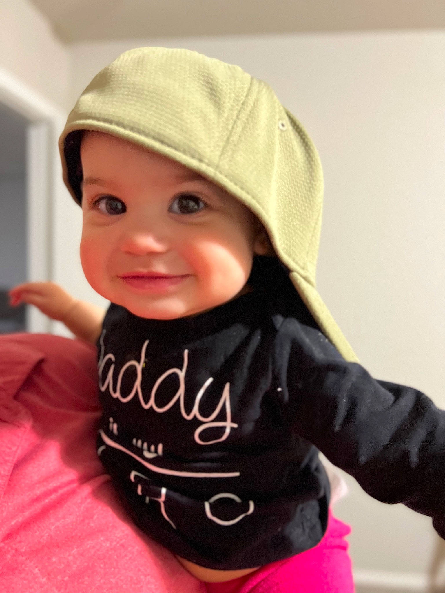 Maya is registered to the contest to win money with this photo: baby, baby_toddler_clothing, cap, cheek, child, clothing, fashion_accessory, finger, happy, headgear, headwear, hood, lip, outerwear, person, personal_protective_equipment, sitting, skin, sleeve, smile
