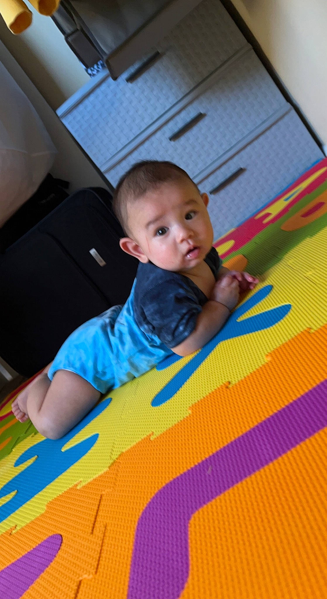 Cory is registered to the contest to win money with this photo: baby, baby_toddler_clothing, carpet, child, comfort, electric_blue, floor, flooring, fun, leisure, linens, orange, pattern, person, play, playmat, room, sitting, surprise, t_shirt