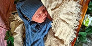 Walker joined the competition — help win amazing prizes! newborn, baby, sleeping, blue_outfit, hat, blanket, wooden_cradle, flowers, roses, soft_texture, cozy, peaceful, infant, portrait, indoors, decorative, resting, cute, child, wrapped