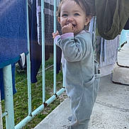 Kayla a rejoint le concours — aidez-le/la à gagner de superbes lots ! toddler, child, baby, balcony, clothing, laundry, railing, outdoor, smiling, snack, footwear, daylight, playful, casual, portrait, person, happy, curly_hair, concrete_floor, jumpsuit