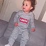 Kayla a rejoint le concours — aidez-le/la à gagner de superbes lots ! toddler, child, indoor, person, sofa, gray_clothing, socks, pony_tail, earrings, couch, casual, home, levis, sweatshirt, pants, standing, furniture, door, wall, young_child