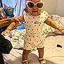 toddler, child, sunglasses, pink, standing, bed, hand, support, clothing, footwear, indoor, blanket, window, curtain, person, smile, happy, home, cute, accessory