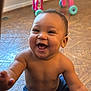 baby, child, smiling, happy, indoor, floor, toy, walker, pants, bare_chest, reaching, cute, infant, person, young_child, playtime, joy, expression, sitting, room
