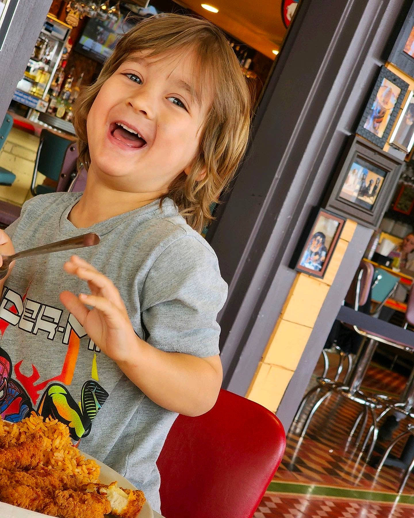 Sullivan is registered to the contest to win money with this photo: baking, blond, brown_hair, chair, child, comfort_food, convenience_food, cuisine, customer, food, fun, happy, junk_food, natural_foods, orange, person, recreation, retail, smile, sweetness