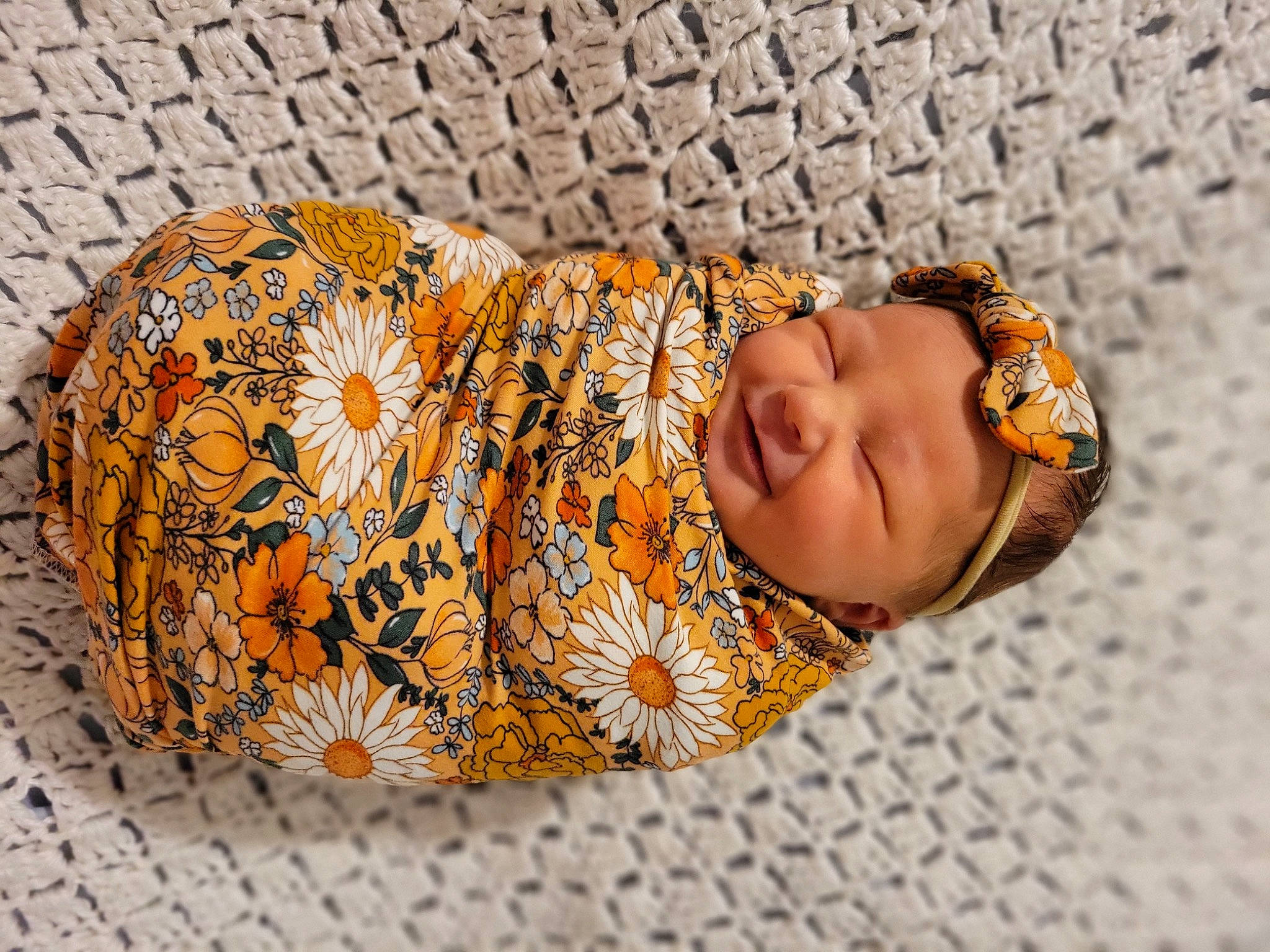 Isla joined the competition — help win amazing prizes! baby, beanie, child, comfort, fashion_accessory, flooring, fun, grass, happy, head, headgear, headwear, knit_cap, linens, orange, pattern, person, portrait_photography, smile, toddler