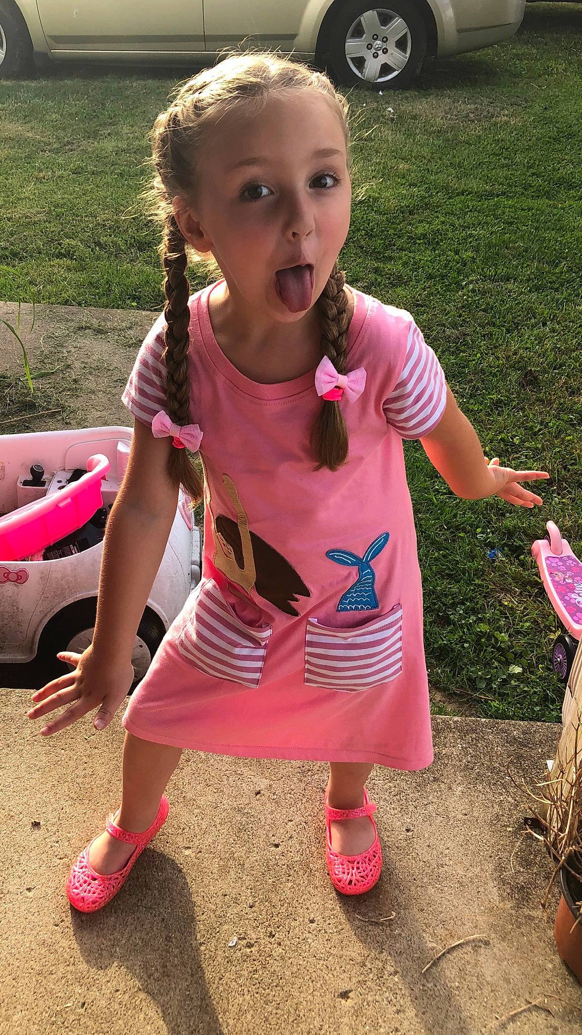 Scotlyn is registered to the contest to win money with this photo: baby_toddler_clothing, bumper, child, facial_expression, family_car, fun, grass, happy, leisure, magenta, pattern, person, pink, play, recreation, sandal, sneakers, t_shirt, toddler, vehicle_door