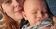Declan is registered to the contest to win money with this photo: baby, child, closeup, comfortable, couch, expression, face, family, indoor, infant, love, mother, person, portrait, pout, resting, snuggle, striped_clothing, tender, woman