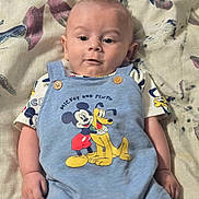Declan joined the competition — help win amazing prizes! baby, cartoon_print, casual, child, clothing, cute, expression, eyes, face, hand, indoor, infant, lying_down, mickey_mouse, overalls, patterned_blanket, pluto, portrait, skin, soft_lighting