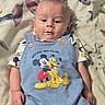 Declan joined the competition — help win amazing prizes! baby, blue_overall, child, clothing, curious, cute, expression, face, head, indoor, infant, lying_down, mickey_mouse, patterned_blanket, person, pluto, portrait, small_hands, soft_lighting, young_child