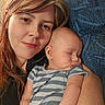 Declan is registered to the contest to win money with this photo: woman, baby, sleeping, striped_clothing, couch, blue_couch, portrait, indoor, relaxed, closeup, person, head, face, child, infant, holding, comfort, resting, casual, home