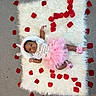 baby, infant, pink_tutu, rose_petals, white_rug, fluffy_rug, flower_accessories, headband, laying_down, cute, adorable, portrait, child, soft_texture, decorative, celebration, home, floor, skin, clothing
