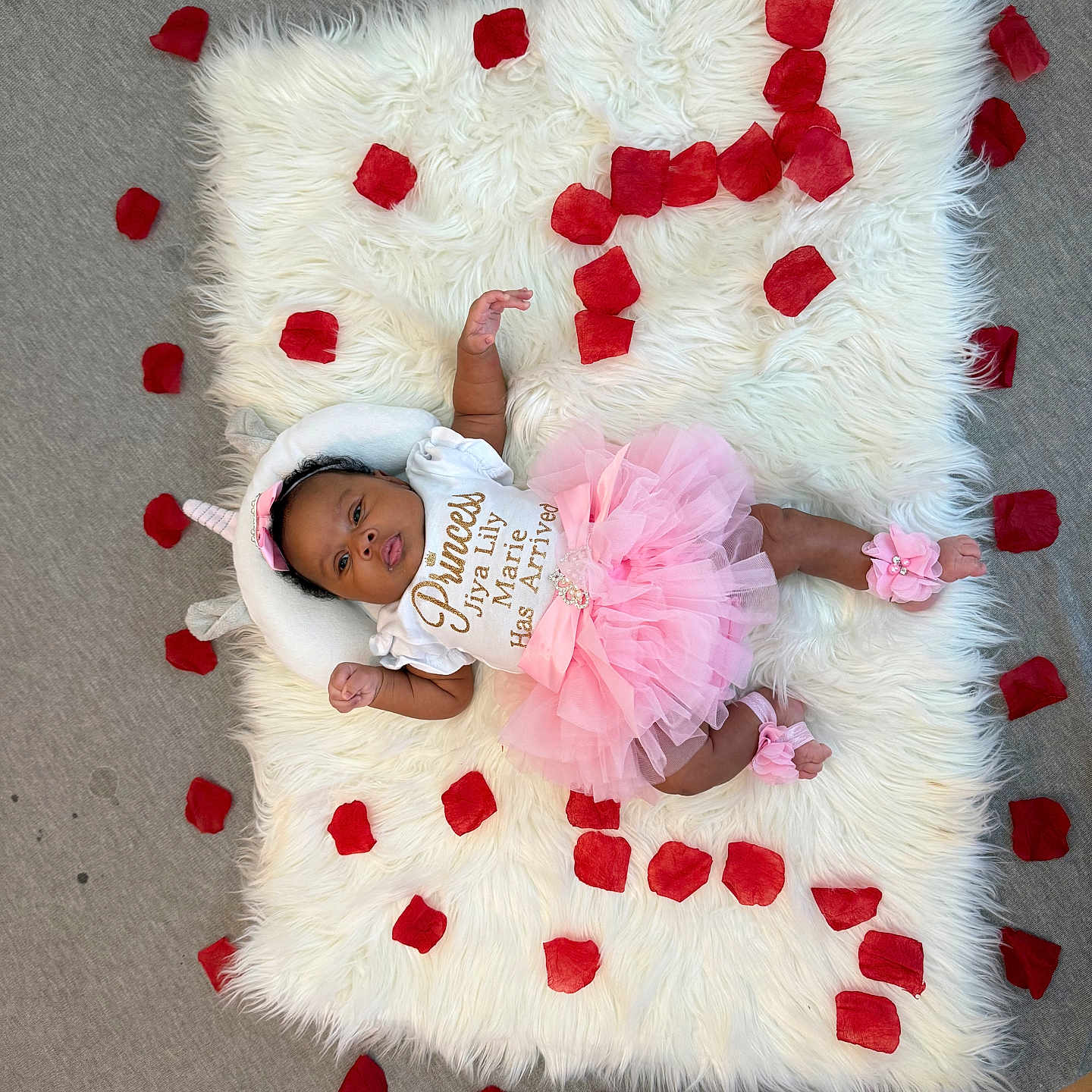 Jiya is registered to the contest to win money with this photo: baby, infant, pink_tutu, rose_petals, white_rug, fluffy_rug, flower_accessories, headband, laying_down, cute, adorable, portrait, child, soft_texture, decorative, celebration, home, floor, skin, clothing