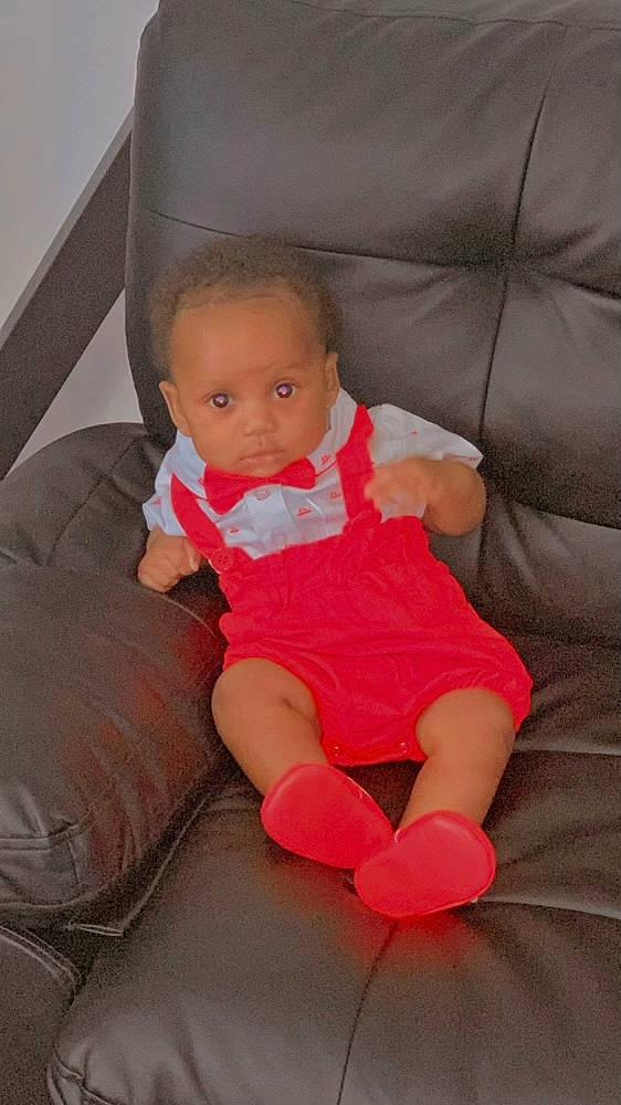 Jacob is registered to the contest to win money with this photo: baby, baby_toddler_clothing, cheek, comfort, couch, eye, face, finger, head, human_body, human_leg, knee, lap, leg, mouth, person, skin, sock, thigh, thumb