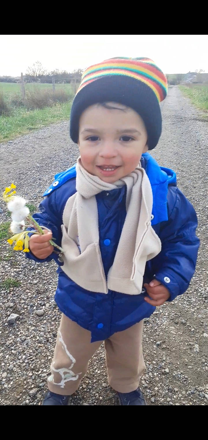 Ismaël participe au concours pour gagner de l'argent avec cette photo : blue, cap, child, electric_blue, eye, face, fun, glove, grass, happy, headwear, jacket, joy, outerwear, people_in_nature, person, photograph, plant, sleeve, smile