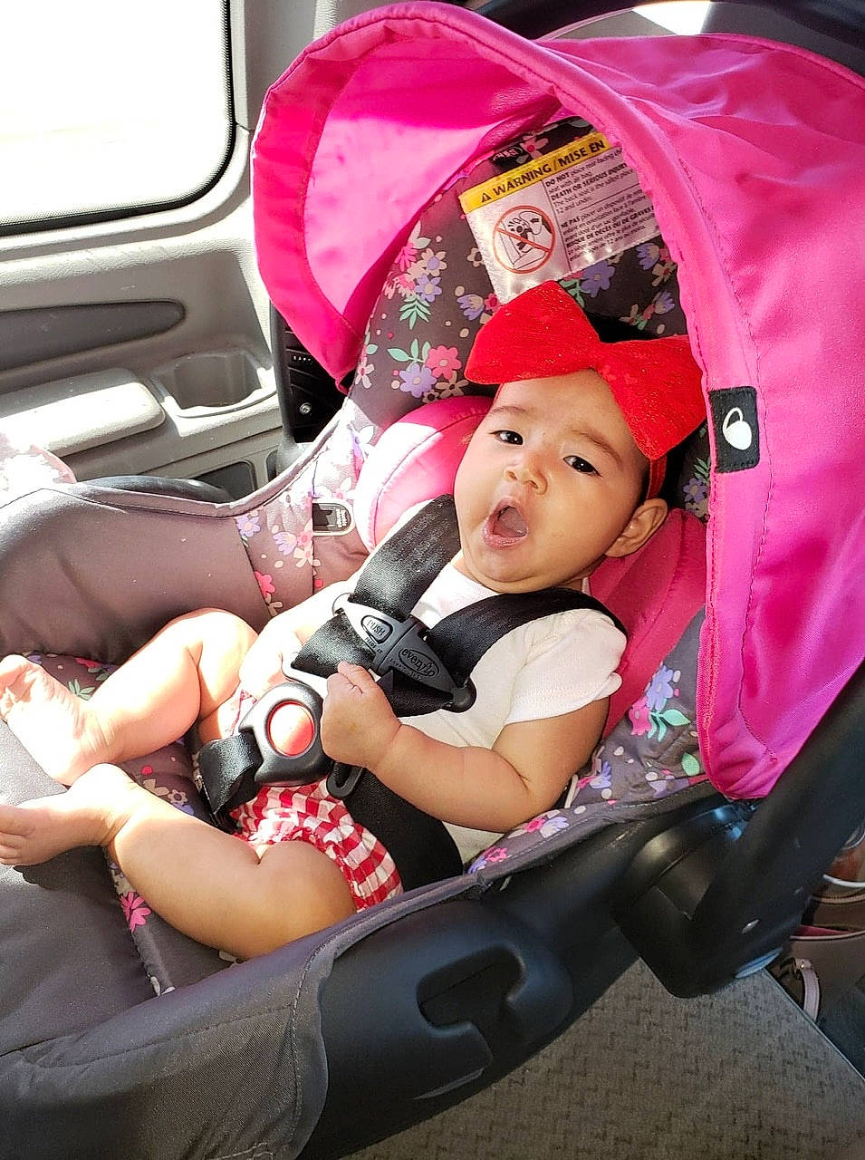 Aria is registered to the contest to win money with this photo: baby, baby_carriage, baby_in_car_seat, baby_products, car, car_seat, car_seat_cover, child, headwear, person, pink, product, toddler, vacation, vehicle