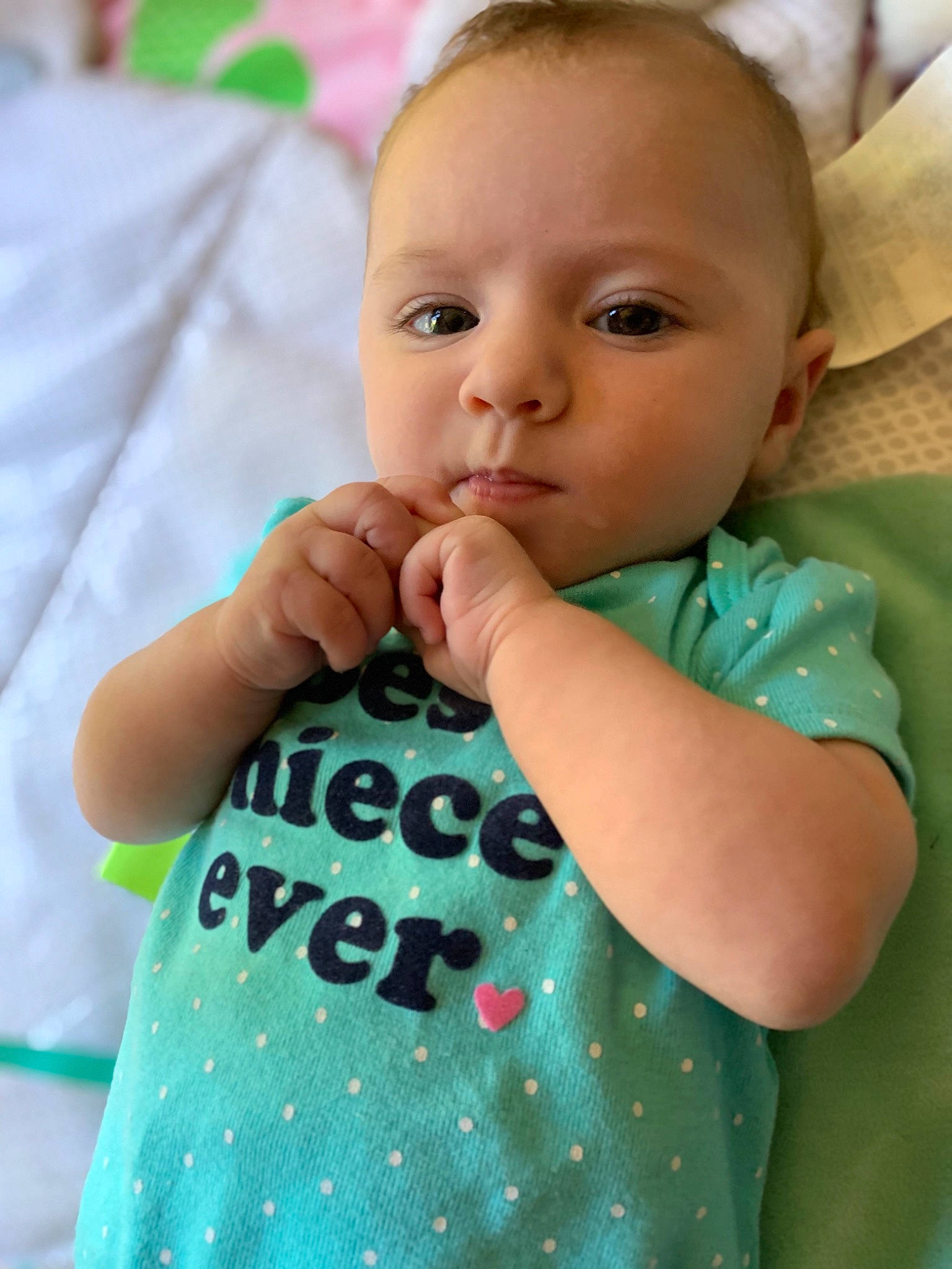 Sienna Joy is registered to the contest to win money with this photo: baby, baby_toddler_clothing, cheek, child, eye, face, finger, green, hand, head, lip, neck, nose, pattern, person, skin, toddler