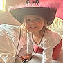 Lilou a rejoint le concours — aidez-le/la à gagner de superbes lots ! toddler, child, hat, cowboy_hat, pink, bed, white_sheets, smiling, crawling, indoor, person, cute, happy, long_sleeve_shirt, pants, window, natural_light, face, hair, playful
