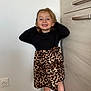 Lilou a rejoint le concours — aidez-le/la à gagner de superbes lots ! child, girl, smiling, leopard_print, skirt, black_top, standing, indoor, corner, floor_tile, wall, cabinet, happy, pose, young, person, feet, hair, fashion, cute