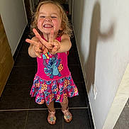 Lilou participe au concours pour gagner de l'argent avec cette photo : child, girl, smiling, happy, dress, pink, sandals, shadow, hallway, floor, tile, wall, indoor, person, playful, gesture, cute, hair, standing, footwear