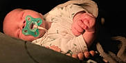 Jude a rejoint le concours — aidez-le/la à gagner de superbes lots ! baby, blanket, child, closeup, clothing, comfort, cozy, cute, dark_background, face, hand, indoors, infant, newborn, pacifier, peaceful, portrait, resting, sleeping, soft_light