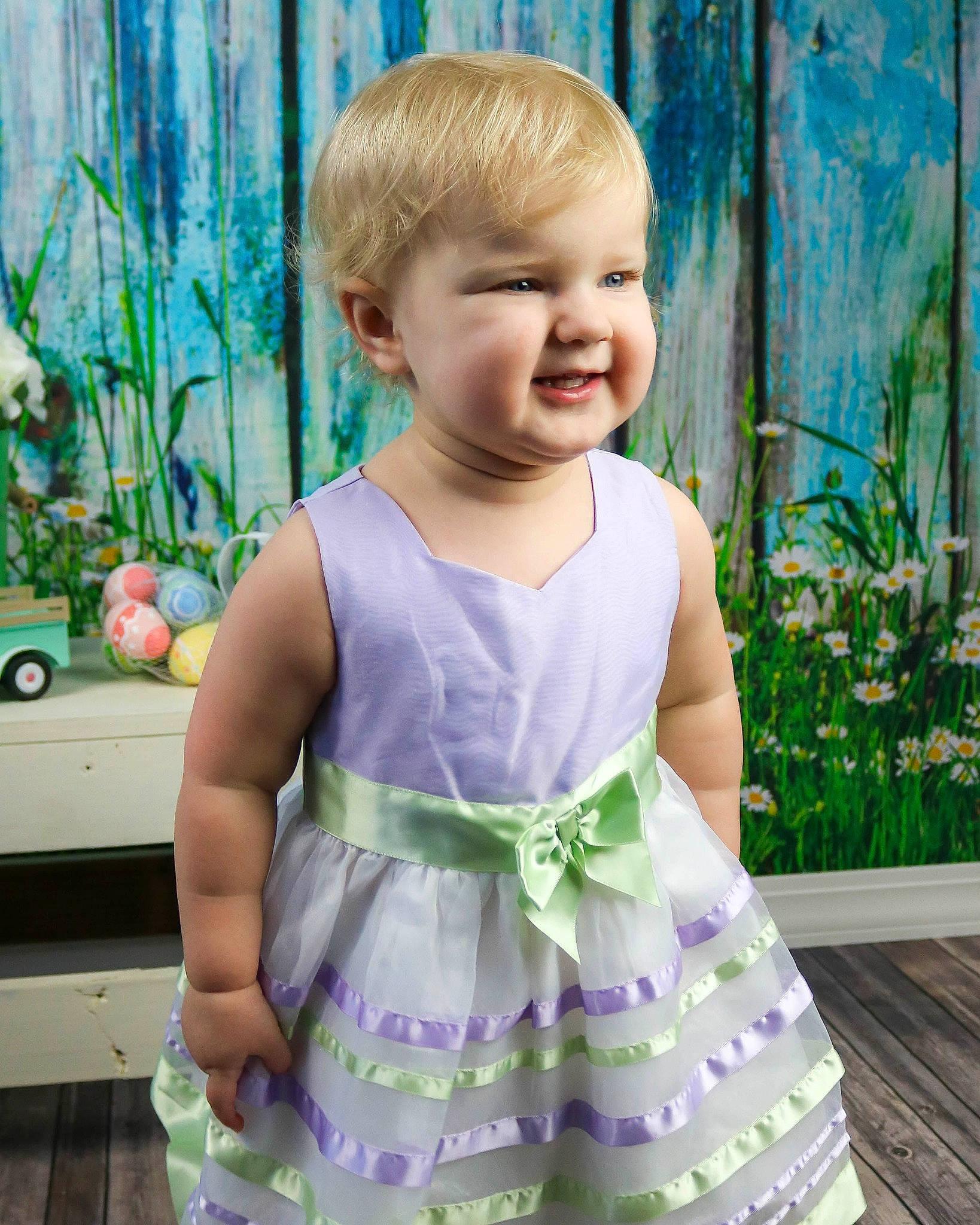 Marnie is registered to the contest to win money with this photo: baby, baby_toddler_clothing, child, child_model, clothing, dress, green, happy, lavender, pattern, person, pink, purple, ruffle, sleeve, smile, toddler