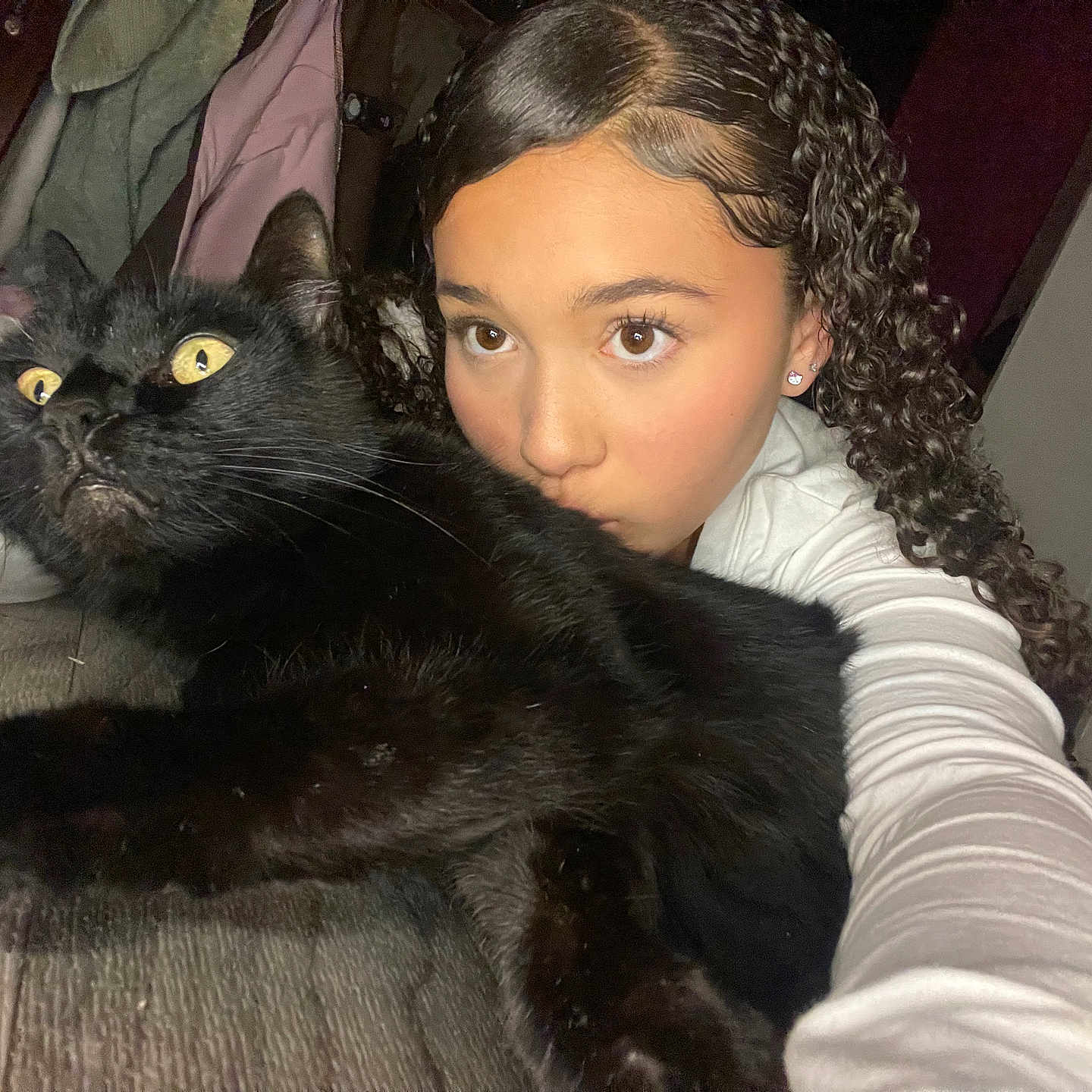Nieko is registered to the contest to win money with this photo: animal, bed, black_cat, blanket, casual, cat, cozy, curly_hair, expression, face, feline, girl, holding, indoor, pet, portrait, selfie, white_shirt, wide_eyes, young_person