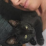 Mavis joined the competition — help win amazing prizes! cat, black_cat, person, selfie, portrait, cuddling, pet, companion, green_eyes, close_up, face, nose_ring, indoors, couch, sitting, relaxed, black_fur, whiskers, animal, photography