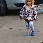 Brooklyn is registered to the contest to win money with this photo: child, sidewalk, car, blond_hair, jacket, leggings, blue_shoes, walking, outdoor, curly_hair, vehicle, person, casual, street, concrete, toddler, daytime, urban, parked_car, curb