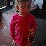 Brooklyn is registered to the contest to win money with this photo: child, indoor, pink_hoodie, curly_hair, snack_bag, barefoot, floor, toy_vehicle, curious_expression, skirt, messy_hair, young_girl, home, carpet, wooden_floor, person, standing, casual_clothing, dim_lighting, living_space