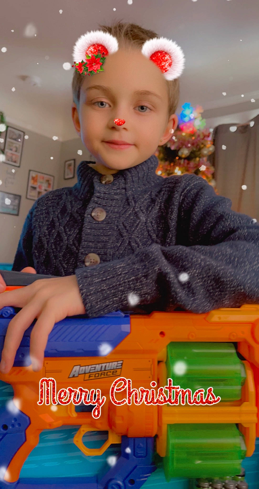 Bently joined the competition — help win amazing prizes! baby_toddler_clothing, child, christmas_decoration, christmas_ornament, christmas_tree, event, fashion_accessory, fun, happy, headpiece, headwear, holiday, joy, pattern, person, play, room, sitting, sleeve, smile