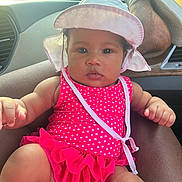 Naziyah is registered to the contest to win money with this photo: baby, child, infant, swimsuit, hat, polka_dot, pink, car_interior, seat, sunlight, person, foot, relaxing, summer, cute, portrait, window, skin, hand, closeup