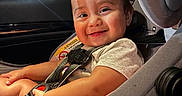 Gianna joined the competition — help win amazing prizes! toddler, child, car_seat, smiling, happy, seatbelt, indoor, car_interior, baby, clothing, sitting, person, cute, face, head, shorts, hands, safety, baby_car_seat, infant