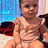 Gianna is registered to the contest to win money with this photo: baby, infant, child, pink_clothing, sitting, bed, curious_expression, indoors, blanket, curtain, soft_light, portrait, human, skin, face, hand, legs, room, young_child, cute