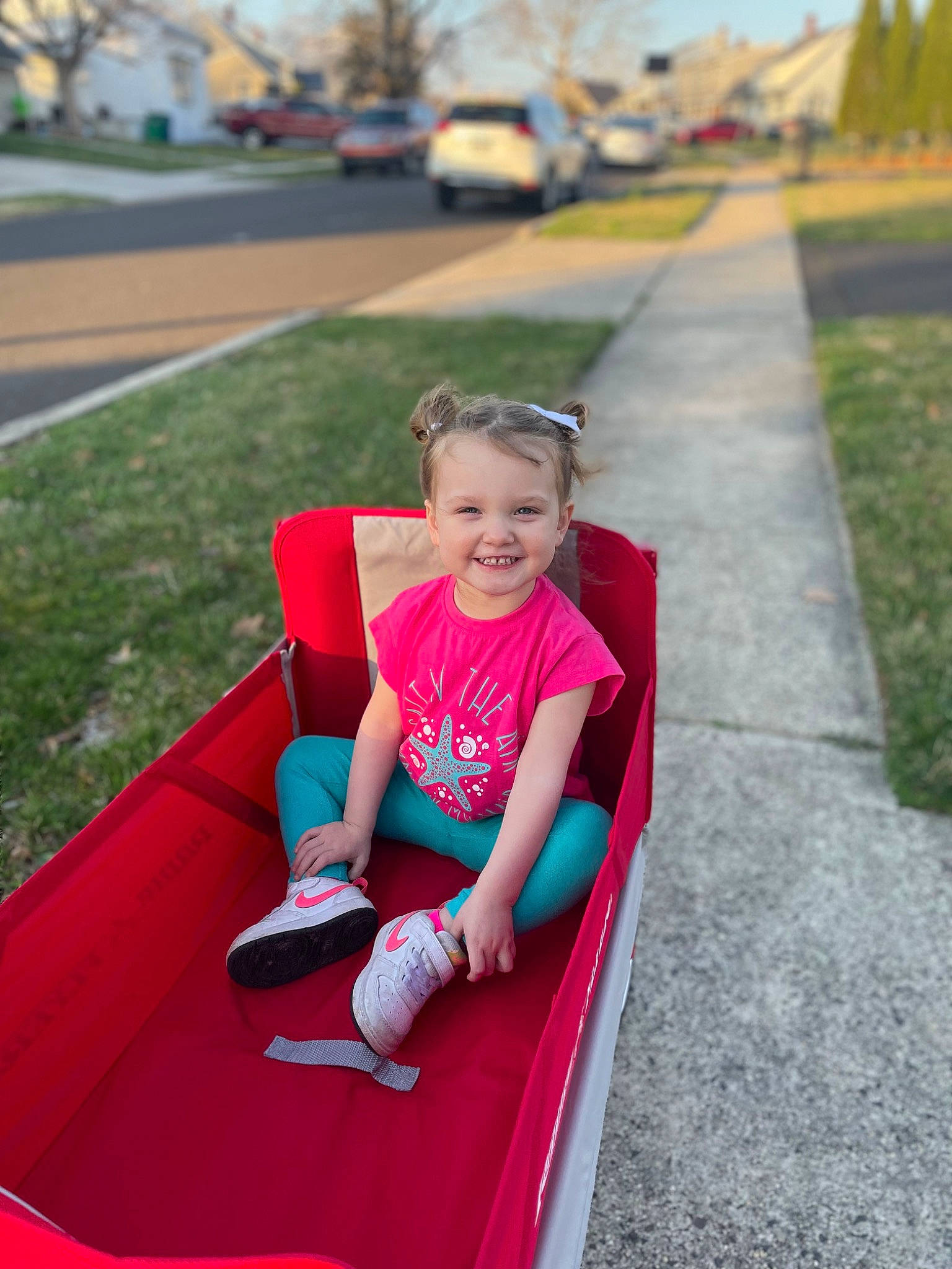 Keagan is registered to the contest to win money with this photo: asphalt, automotive_design, automotive_exterior, bumper, car, dress, eye, grass, happy, joy, leisure, motor_vehicle, person, pink, plant, shorts, smile, sneakers, summer, toddler