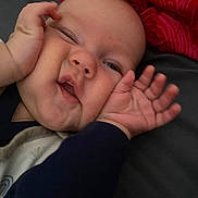 Manoë a rejoint le concours — aidez-le/la à gagner de superbes lots ! baby, child, face, hands, expression, squished_face, red_blanket, clothing, couch, skin, infant, cute, portrait, indoor, person, head, smile, funny_face, closeup, young
